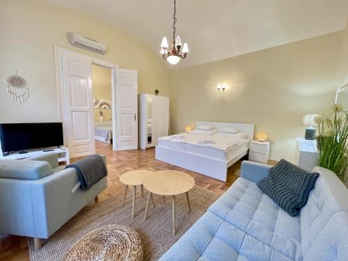 a living room with a blue couch and a bed at Appartement Bohème Budapest in Budapest