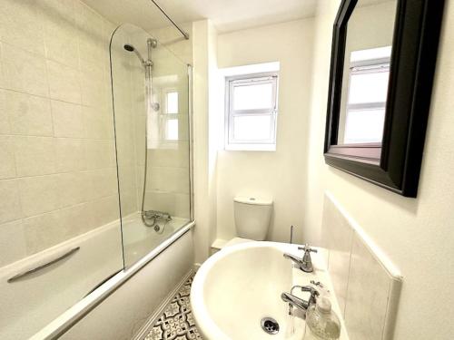 ein weißes Bad mit einem Waschbecken und einer Dusche in der Unterkunft Riverside View by Blue Skies Stays in Middlesbrough
