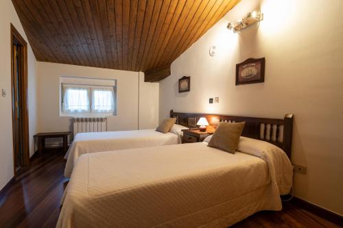 a hotel room with two beds and a window at Posada La Olma in Polientes