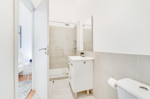 a white bathroom with a sink and a shower at Fornos Deluxe Apartments in Lisbon