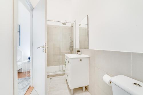 uma casa de banho branca com um lavatório e um chuveiro em Fornos Deluxe Apartments em Lisboa