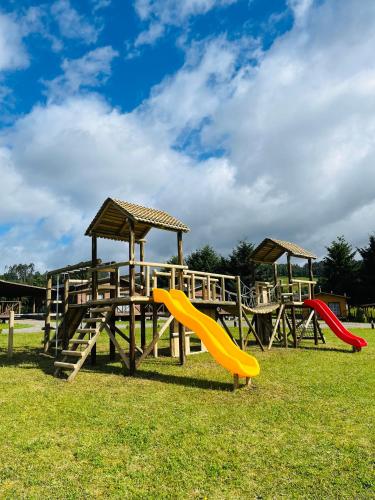 a playground with two slides and a play structure at Cabañas Rimü - Cabaña para 2 personas in Futrono