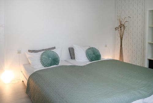 a bedroom with a green bed with white pillows at Landhaus Refugium in Weissach