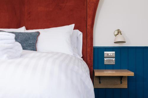 a bedroom with a white bed and a side table at The Chequers Inn in Knebworth