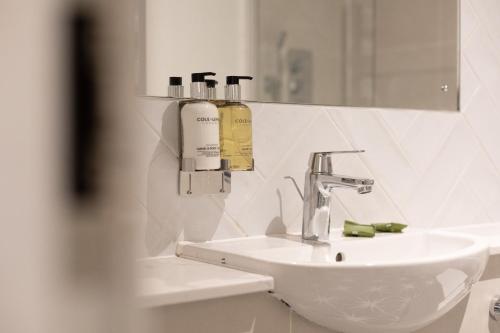 a white bathroom with a sink and a mirror at The Chequers Inn in Knebworth