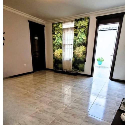 an empty room with a large room with plants on the walls at Hermosa Casa con doble garaje amoblada en el Albergue in Club del Comercio