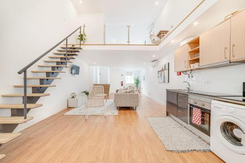 a kitchen and living room with a staircase in a loft at Fornos Deluxe Apartments in Lisbon