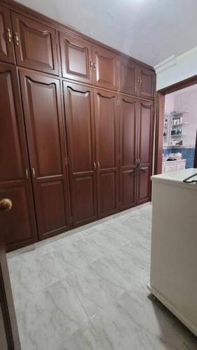 a kitchen with wooden cabinets and a white refrigerator at Hermosa Casa con doble garaje amoblada en el Albergue in Club del Comercio