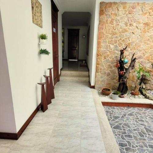 a hallway of a house with a stone wall at Hermosa Casa con doble garaje amoblada en el Albergue in Club del Comercio