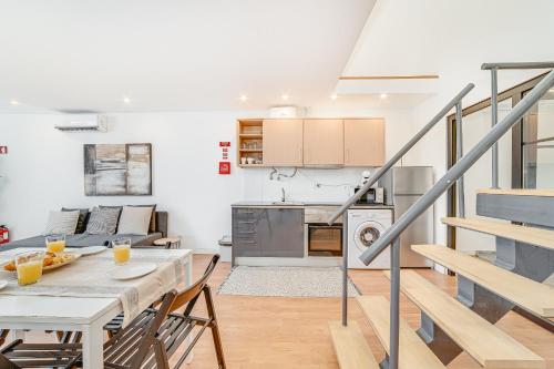 a kitchen and a dining room with a table and chairs at Fornos Deluxe Apartments in Lisbon