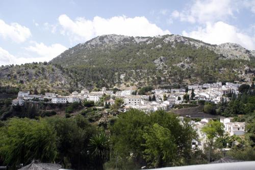 a village on a hill with a mountain in the background at Villa Turística de Grazalema in Grazalema