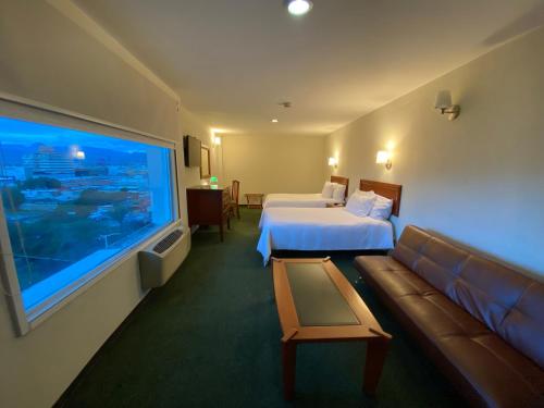 a hotel room with a bed and a large window at Hotel Enterprise Inn Poliforum in León