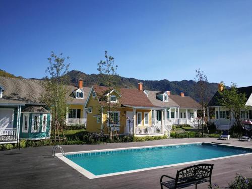 a house with a swimming pool in the yard at Vermont Khao Yai Resort in Ban Na Sok