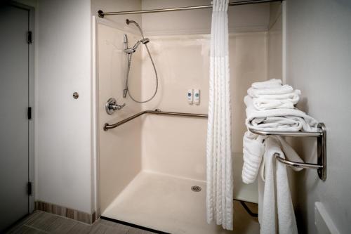 a bathroom with a shower and white towels at Comfort Suites Prestonsburg West in Prestonsburg