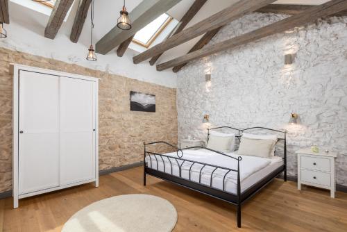 um quarto com uma cama e uma parede de pedra em Villa Ivka em Tribalj