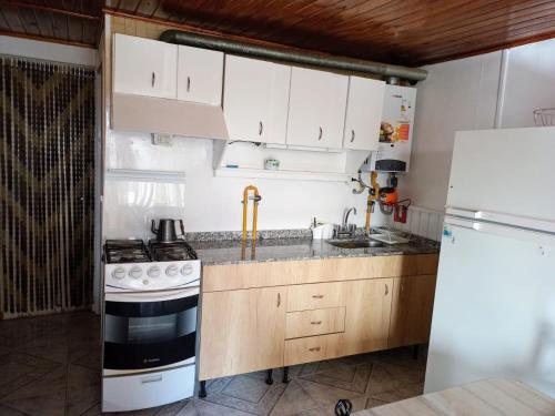 a kitchen with a stove and a white refrigerator at Hermosa casa de vacaciones en Mendoza in Guaymallen