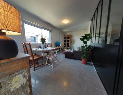 un salon avec une table et un canapé dans l'établissement T2 de charme proche de Bordeaux, au Haillan