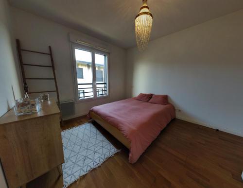 une chambre avec un grand lit et une fenêtre dans l'établissement T2 de charme proche de Bordeaux, au Haillan