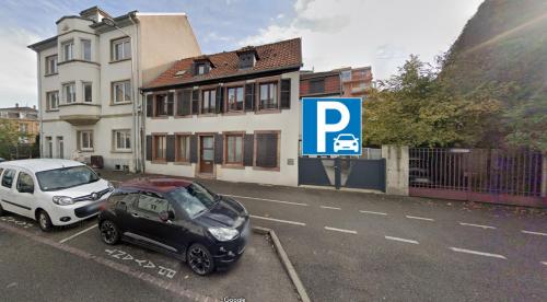 Deux voitures garées dans un parking à côté d'une maison dans l'établissement Le Roesselmann 1 parking, à Colmar