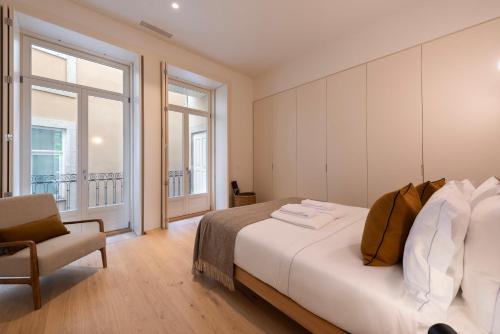 a bedroom with a large bed and a chair at Mouzinho 32 in Porto