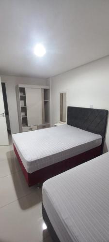 a bedroom with two beds in a room at Apartamentos na cobertura - Edifício London - Com Ar-condicionado em todos os cômodos in Piratuba