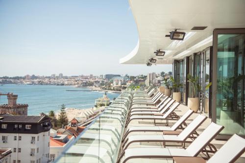 EVOLUTION Cascais-Estoril Hotel في استوريل: صف من كراسي الصالة البيضاء على مبنى مطل على الماء