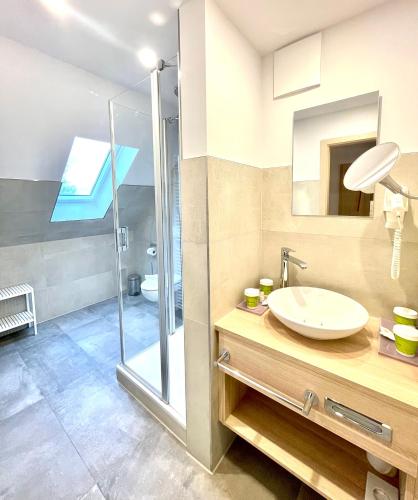 a bathroom with a sink and a shower at Ferienhotel Alter Bahnhof garni in Prerow