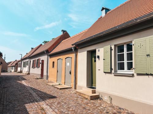 eine Reihe von Häusern mit grünen Türen und einer Straße in der Unterkunft Kyritzer Budenhaus (Nr. 105) in Kyritz