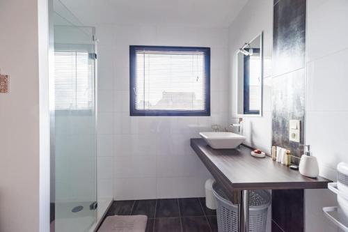 a bathroom with a sink and a glass shower at Maison de vacances à Pordic - proche de la mer in Pordic