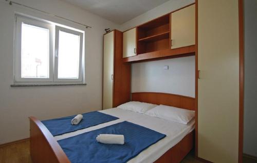 a bedroom with a bed with blue sheets and a window at Apartment Ćule in Senj