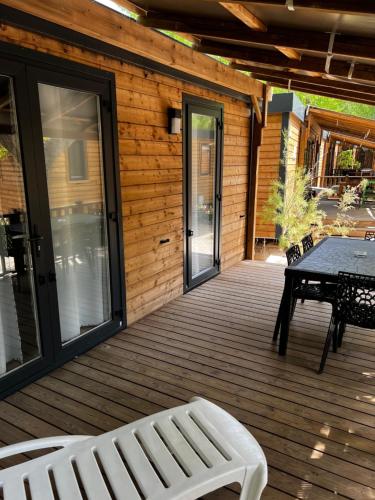 una terraza de madera con una mesa y un banco. en Best Holiday Port Grimaud, en Grimaud
