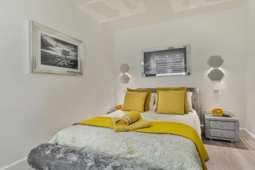 a bedroom with a bed with a yellow blanket on it at Tudor House Holidays - The Apartment for 2 people in Scarborough