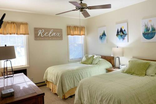 a bedroom with two beds and a ceiling fan at Mountainside Condo @ Jiminy Peak in the Berkshires in Hancock