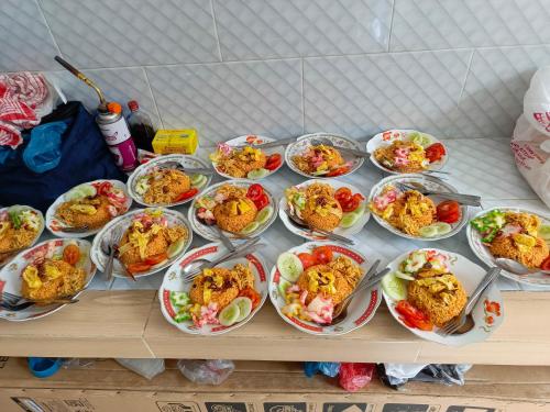 PadangluarにあるMutiara Guest House Syariahの多皿のテーブル