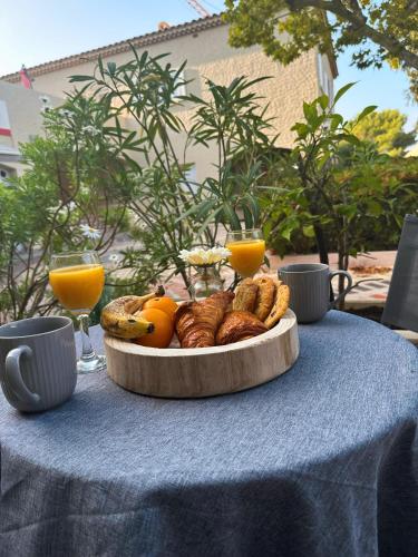 une assiette de pain et de fruits sur une table dans l'établissement Duplex cosy bord de Mer, à Saint-Cyr-sur-Mer