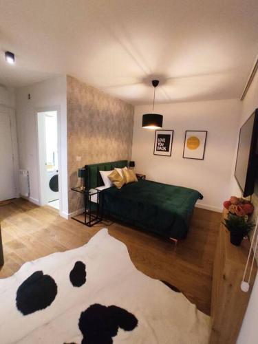 een slaapkamer met een bed met een groene deken bij Aria in Belgrado