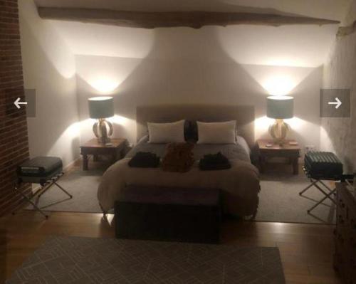 a bedroom with a bed and two lamps on two tables at Bulles & Bubbles... in Juvancourt