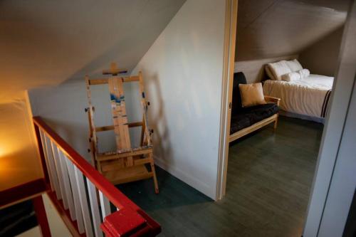 a attic room with a bed and a ladder and a stairway at The Cozy Red Cabin in Bellevue