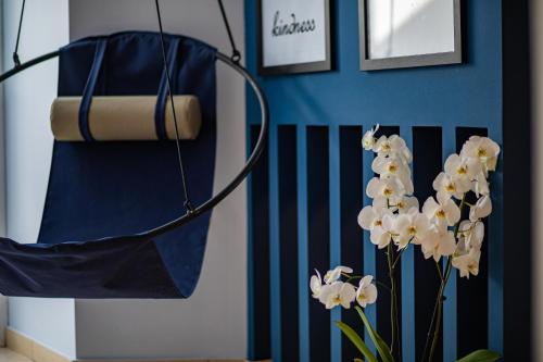 a vase with white flowers and a blue wall at VillasDiNafplio - DIVA & PERLA in Nafplio