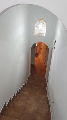 a stairway with a white wall and a hallway at Casa Luisa - Casa Completa con Encanto Valdepeñas in Valdepeñas