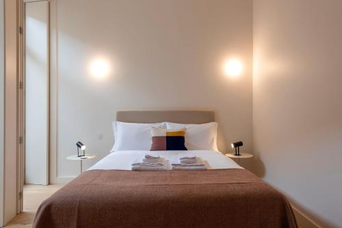 a bedroom with a large bed with two towels on it at Mouzinho 32 in Porto