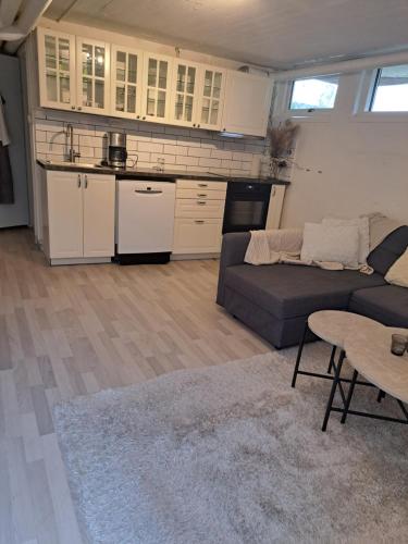 a kitchen and a living room with a couch and a table at Lägenhet Huskvarna in Jönköping