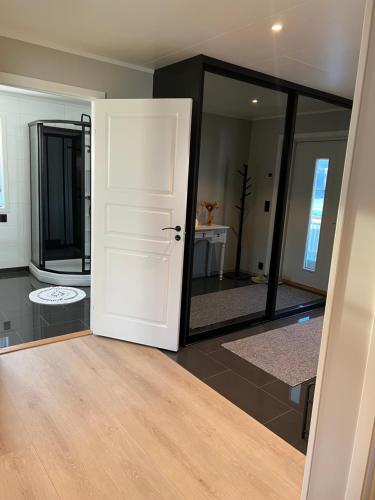 Habitación con puerta blanca y espejo. en Villaveien, en Sortland