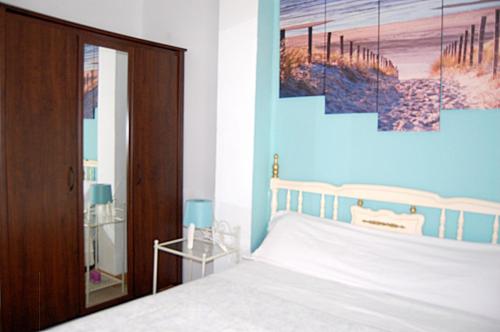 um quarto com uma cama com uma parede azul em Apartamento San Juan de Dios em Sevilha