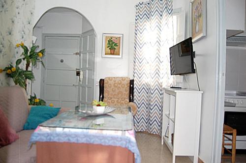 a living room with a table and a tv at Apartamento San Juan de Dios in Seville
