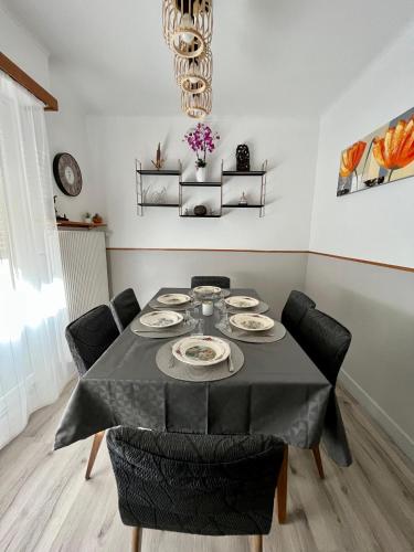 une salle à manger avec une table et des chaises noires dans l'établissement Townhouse - Strasbourg Robertsau, à Strasbourg