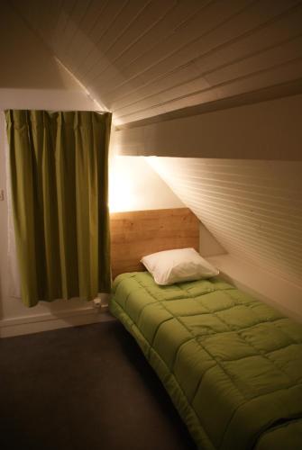 - une chambre avec un lit vert et une fenêtre dans l'établissement VVF Amboise Les Châteaux de la Loire, à Amboise