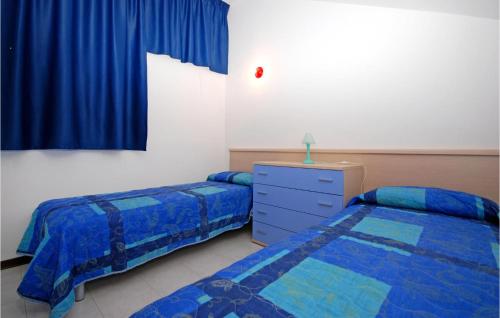 sypialnia z 2 łóżkami, komodą i oknem w obiekcie Holiday Village w Lignano Sabbiadoro