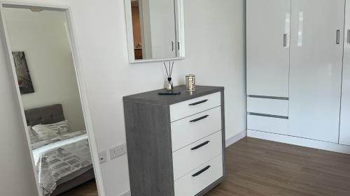 a room with a dresser with a mirror and a bed at Al Raha lofts 1 in Al Qurayyah