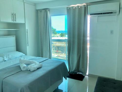 a bedroom with a bed with towels on it at Apartamento super novo, ótima localização na praia do Recreio! in Rio de Janeiro
